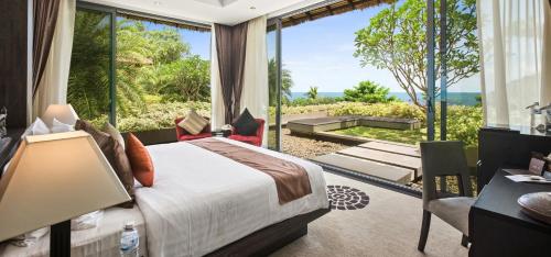 a bedroom with a bed and a large window at Sangsuri Villa 3 in Choeng Mon Beach