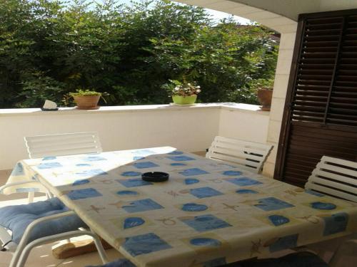 stół i krzesła na werandzie ze stołem i krzesłami w obiekcie Apartments Magda w mieście Supetar