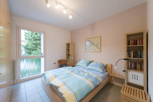 a bedroom with a bed and a book shelf at Appartamento Fronte Lago in Riva del Garda