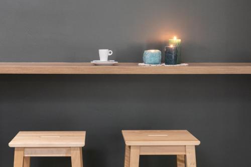 a shelf with two wooden tables and a candle at Boutique Hôtel Azur in Marseille