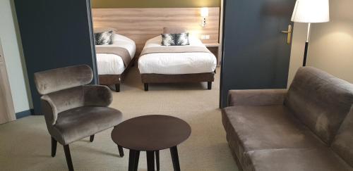 a room with a bed and a couch and a chair at Best Western Crequi Lyon Part Dieu in Lyon