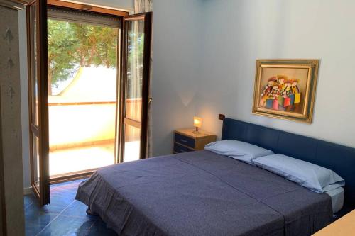 una camera con un letto blu e una finestra di Casa Alexandr Piedigrotta a Pizzo
