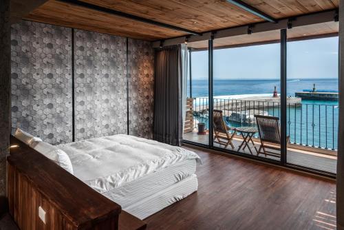 a bedroom with a bed and a view of the ocean at Marbordo B&B in Xiaoliuqiu