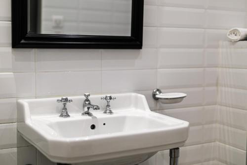 a white sink in a bathroom with a mirror at Boutique Hôtel Azur in Marseille