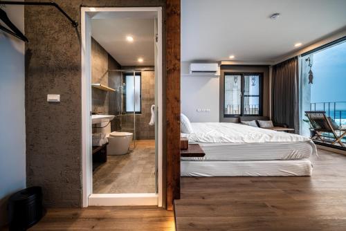 a bedroom with a bed and a bathroom at Marbordo B&B in Xiaoliuqiu
