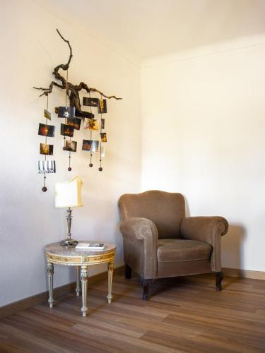 a living room with a chair and a table at Fonte da Rosa Guest House APT2 in Belmonte