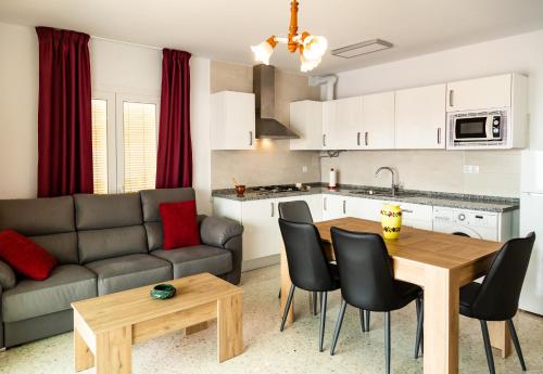 een keuken en een woonkamer met een bank en een tafel bij Apartamento rural Alborada in Cómpeta