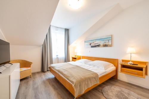 a bedroom with a bed and a large window at Appartment Strandduene in Binz