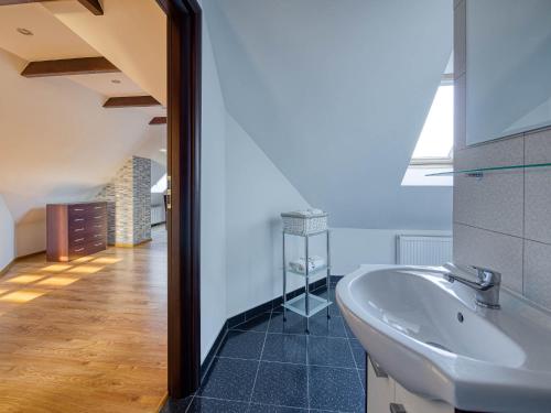 La salle de bains est pourvue d'un lavabo blanc et d'un miroir. dans l'établissement Willa Malinowscy, à Szczawnica
