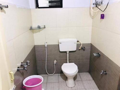 uma pequena casa de banho com WC e chuveiro em mystique inn em Ooty