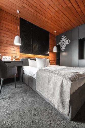 a bedroom with a large bed and a desk at Stara Pravda Hotel - Vykrutasy in Bukovel