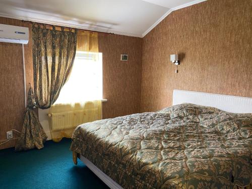 a bedroom with a bed and a window at Avtoport Restorant Hotel Complex in Vinnytsya