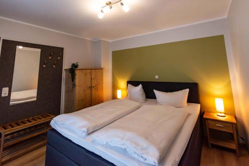 a bedroom with a large bed with white sheets at Hotel und Berggasthof Spießberghaus in Friedrichroda