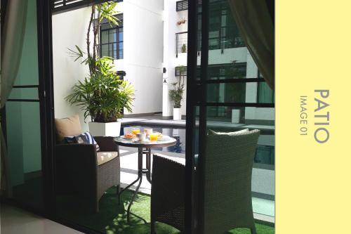 a balcony with a table and chairs in a building at Pool Access 2 BDR Stylish Condo in Kamala Beach