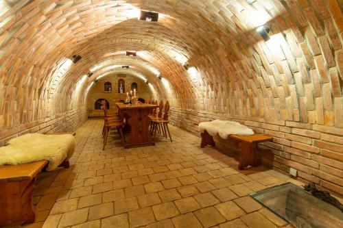a room in a brick tunnel with a table and benches at U Stařenky in Dolní Bojanovice
