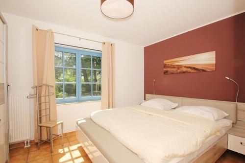 a bedroom with a large bed and a window at Ferienresidenz Kap Arkona FeWo12 - Terrasse in Putgarten