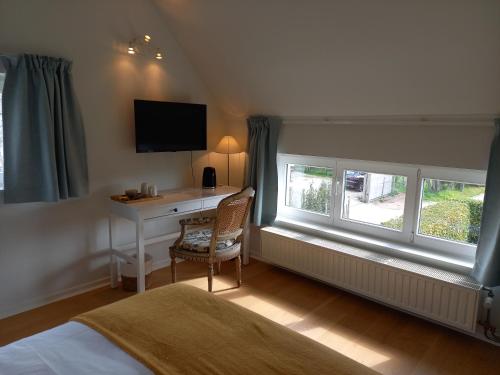 a bedroom with a desk and a bed and a window at little cottage in Lasne