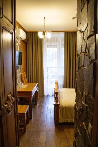 a hotel room with a bed and a desk and a window at Pidkova in Rivne