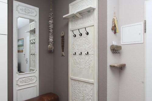 Zimmer mit einer weißen Tür und einem Spiegel in der Unterkunft strandnah mit Terrasse, gratis Nutzung vom AHOI Erlebnisbad und Sauna in Sellin - Strandhaus Mönchgut FeWo09 in Lobbe