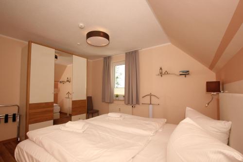 a bedroom with two white beds and a mirror at strandnah mit Balkon, gratis Nutzung vom AHOI Erlebnisbad und Sauna in Sellin - Strandhaus Mönchgut FeWo13 in Lobbe