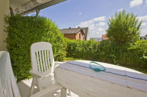 a table and two chairs on a patio at Hafenhäuser Breege FeWo 13 - Terrasse, Meerblick in Breege