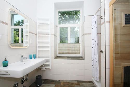 ein weißes Badezimmer mit Waschbecken und Fenster in der Unterkunft Ferienwohnung mit eigener Sauna in zentraler Lage - Kurhaus Nordstrand FeWo 32 in Göhren