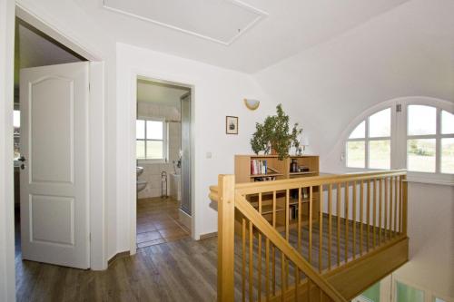 ein Zimmer mit einer Treppe und einem Aoyer mit weißen Wänden in der Unterkunft strandnahe Idylle am Meer, private Badestelle, Strandkorb - Gutshof Ostseeblick in Neuendorf