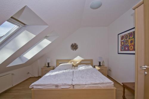 a bedroom with a large bed in a attic at ruhige Lage und mit Gartennutzung, nah am Meer - Höftresidenz FeWo 25 in Alt Reddevitz