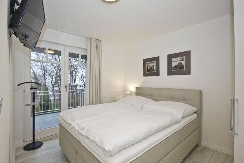 Кровать или кровати в номере moderne Ferienwohnung mit Kamin, Balkon - Ferienresidenz Zwei Bodden FeWo111