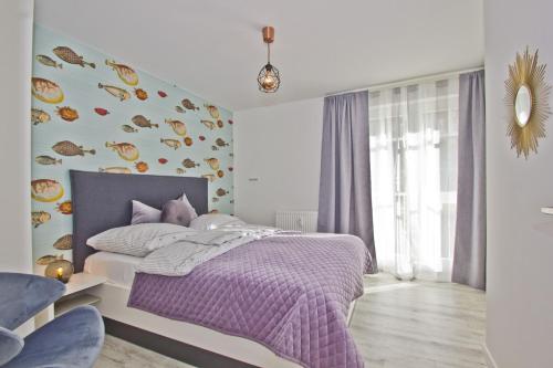 1 dormitorio con cama morada y manta morada en moderne 2-Raum-Ferienwohnung mit Balkon - Ferienresidenz Zwei Bodden FeWo 1-4, en Lietzow