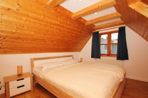a bedroom with a bed and a wooden ceiling at strandnahe, schicke FeWo mit Terrasse und Garten - Ferienwohnung Silas in Thiessow