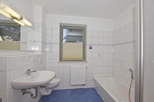 ein Badezimmer mit Waschbecken, Toilette und Badewanne in der Unterkunft Balkon mit Meerblick, ruhige Lage - Ferienhaus Distelfink FeWo 01 in Groß Zicker