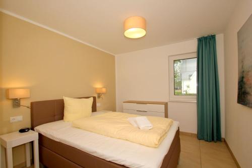 ein Schlafzimmer mit einem Bett mit einem grünen Vorhang in der Unterkunft strandnahe FeWo mit Terrasse, gratis Nutzung vom AHOI Erlebnisbad und Sauna in Sellin - Rex Rugia FeWo 11-1 in Lobbe