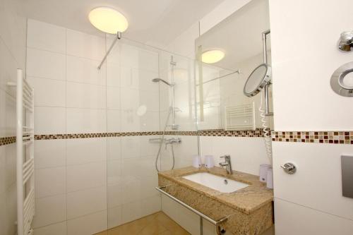 ein Badezimmer mit Waschbecken und Dusche in der Unterkunft strandnahe FeWo mit Terrasse, gratis Nutzung vom AHOI Erlebnisbad und Sauna in Sellin - Rex Rugia FeWo 11-1 in Lobbe