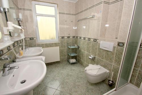 La salle de bains est pourvue d'un lavabo, de toilettes et d'une douche. dans l'établissement mit Meerblick und Balkon, gratis Nutzung vom AHOI Erlebnisbad und Sauna in Sellin - Meeresblick FeWo 35, à Göhren