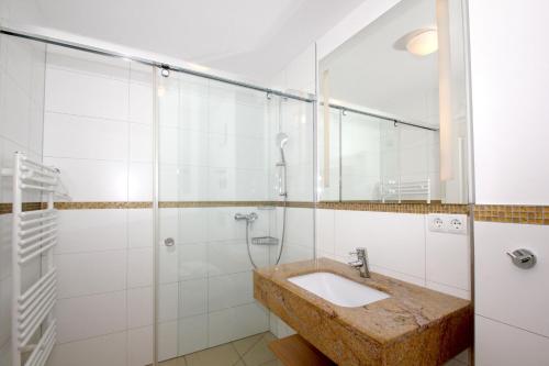 a bathroom with a sink and a shower at strandnahe FeWo mit Terrasse, gratis Nutzung vom AHOI Erlebnisbad und Sauna in Sellin - Rex Rugia FeWo 28-3 in Lobbe