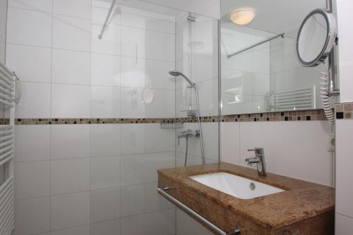 a bathroom with a sink and a shower at strandnahe FeWo mit Balkon, gratis Nutzung vom AHOI Erlebnisbad und Sauna in Sellin - Rex Rugia FeWo 13-8 in Lobbe