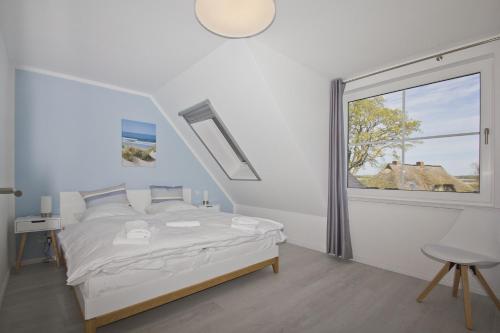 a white bedroom with a bed and a window at mit Meerblick, gratis Nutzung vom AHOI Erlebnisbad und Sauna in Sellin - Haus Inselblick FeWo MEERrauschen in Groß Zicker