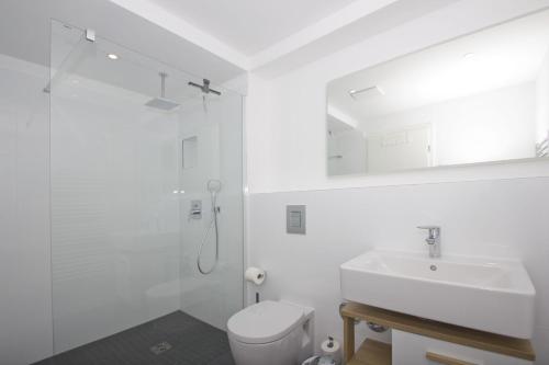 a white bathroom with a sink and a toilet at gratis Nutzung vom AHOI Erlebnisbad und Sauna in Sellin - Haus Inselwind FeWo MEERwind in Groß Zicker
