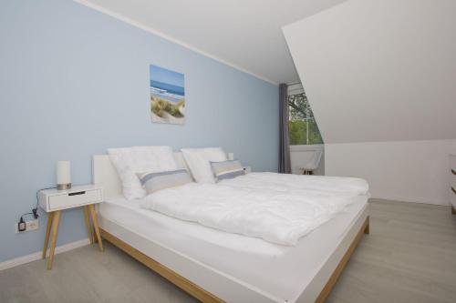 a white bedroom with a large bed with white sheets at gratis Nutzung vom AHOI Erlebnisbad und Sauna in Sellin - Haus Inselwind FeWo MEERwind in Groß Zicker