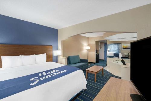 a hotel room with a bed and a living room at Days Inn by Wyndham Panama City in Panama City