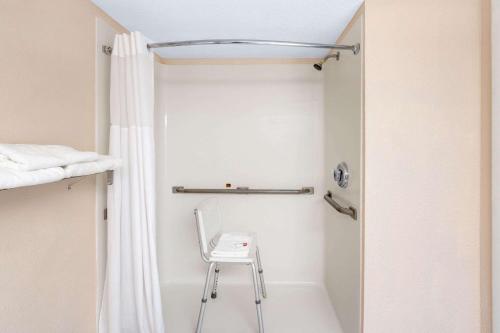 a shower with a chair in a bathroom at Days Inn by Wyndham Panama City in Panama City