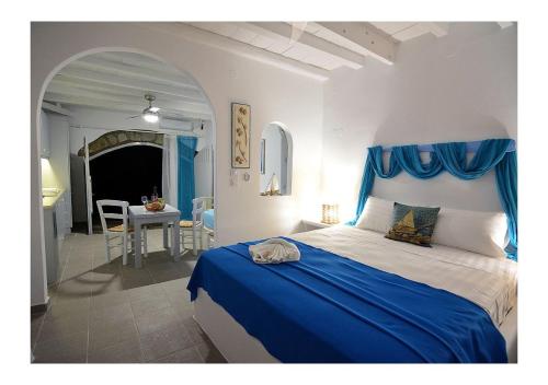 a bedroom with a blue and white bed and a table at Salty Splash & Kyma Sirma Klima in Klima