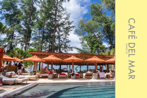 a swimming pool with chairs and umbrellas at Pool Access 2 BDR Stylish Condo in Kamala Beach