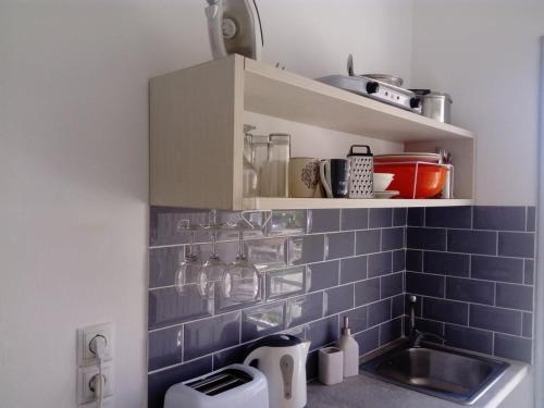 a kitchen with a sink and a blue tiled wall at Erosea Beach Resort in Kavos