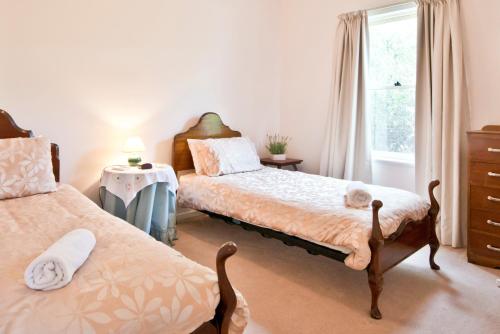 1 dormitorio con 2 camas y ventana en Encounter Hideaway Cottages, en Encounter Bay