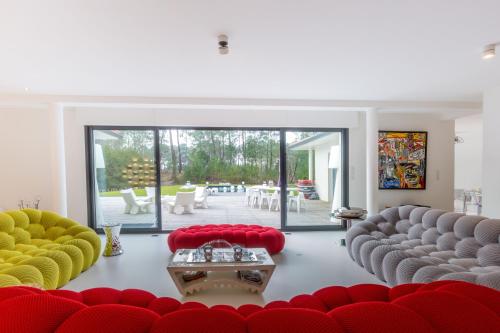 a living room with red and yellow chairs and a table at HOUSE ZYX in Le Touquet-Paris-Plage