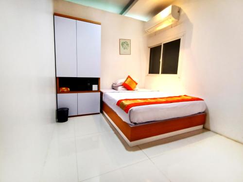 a bedroom with a bed and a television in it at Arawa Traveller's Inn Motel in Makassar