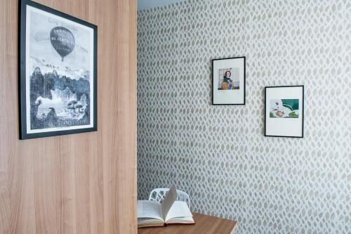 a room with three pictures on a wall with a desk at Hôtel Jules Verne Biarritz in Biarritz