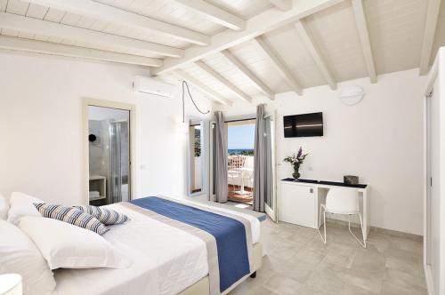- une chambre blanche avec un lit et un balcon dans l'établissement Piccolo Hotel - Adults Only, à Porto Ottiolu